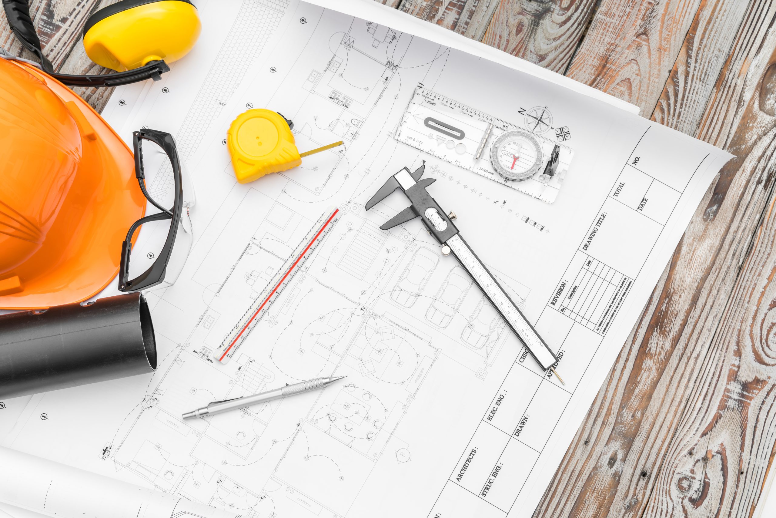 Construction plans with helmet and drawing tools on blueprints 